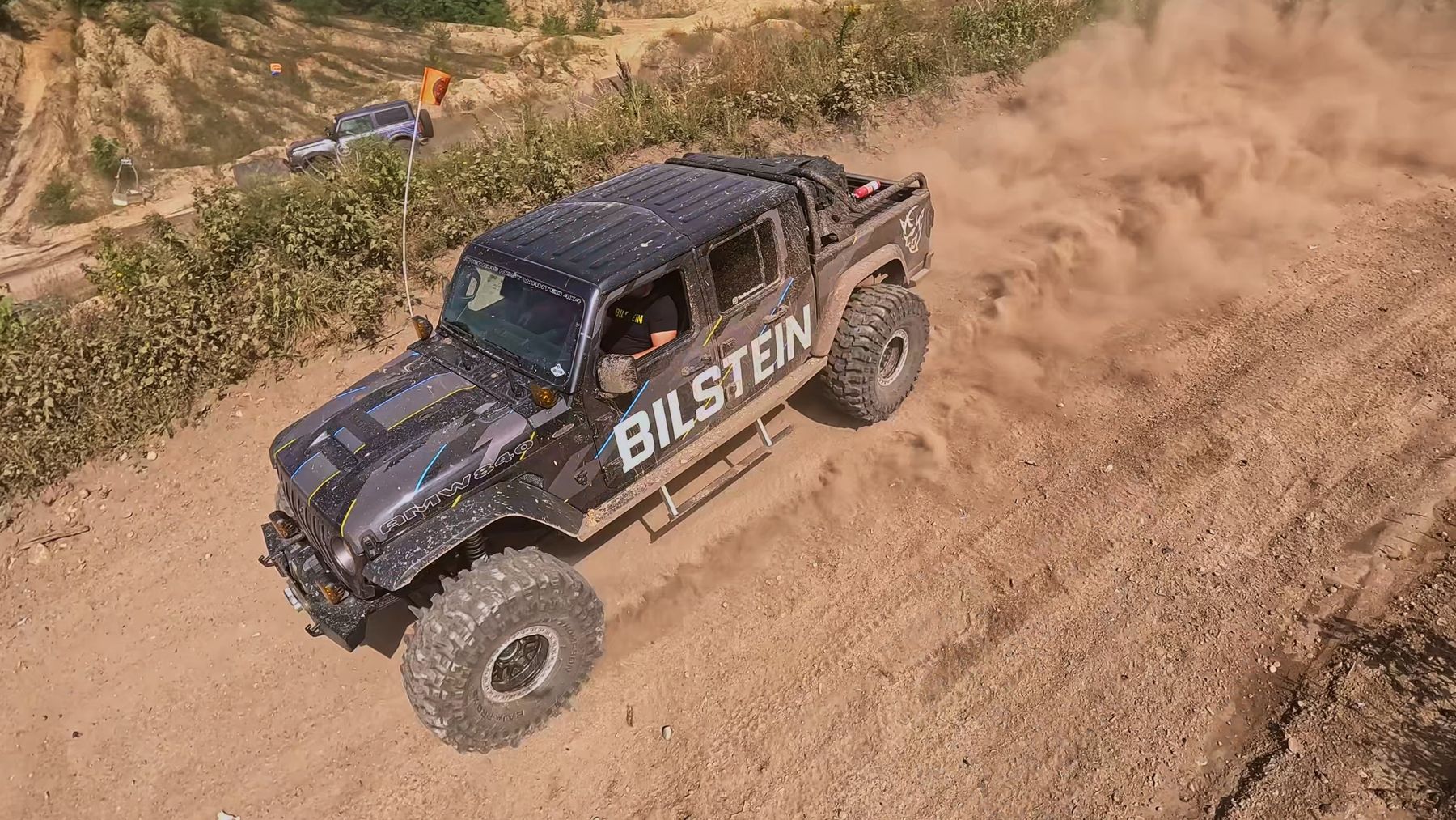 Overhead aerial shot of a Jeep Gladiator kicking up dust on a dirt trail